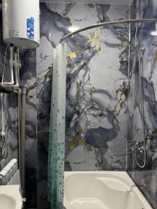a bathroom with a shower and a sink and a tub at Karakalpak Travel in Nukus