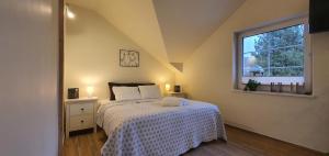 クドヴァ・ズドゥルイにあるVilla Sjesta komfortowe apartamenty, prywatny parking, gratis parking w centrum miastaのベッドルーム1室(白い掛け布団、窓付)