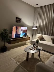 a living room with a couch and a tv at شقة مطلة على البرج - غرفه وصالة in Al Kharj
