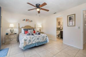 una camera con letto e ventilatore a soffitto di Beachy Retreat - Atlas Duplex a Satellite Beach