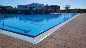 a large swimming pool with blue water in a city at Kleine Bö 2 in Tönning