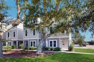 una casa blanca con árboles delante en Beaufort Villas - A&B Duplex, en Beaufort