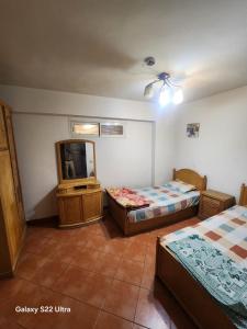 a room with two beds and a tv in it at Porto Sokhna Pyramids Hotel Apartments in Ain Sokhna