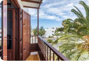 a balcony with a view of palm trees at La casita del puerto in Agaete