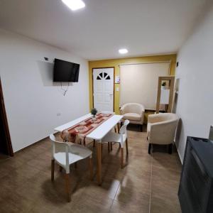 une salle à manger avec une table et des chaises et une télévision dans l'établissement Cabaña en Pto Sta Cruz, à Puerto Santa Cruz 4 autres photos
