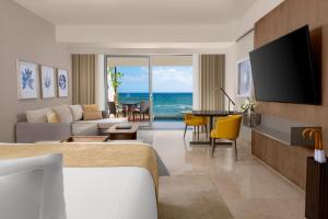 a hotel room with a bed and a living room at Grand Velas Riviera Maya - All Inclusive in Playa del Carmen