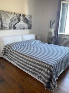 a bed with a striped comforter in a bedroom at Affittacamere L'albero della vita in Sinalunga