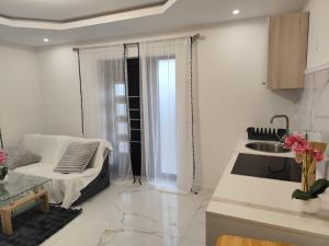 a white living room with a couch and a kitchen at Appartement meublé Rixheim Alsace in Rixheim