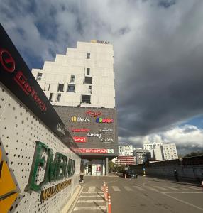 a tall white building in the middle of a street at Theemeraldsuiteapartament in Tirana