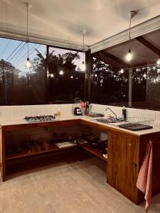 a kitchen with a sink and a large window at Oleadas Maderas in San Juan del Sur