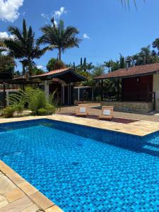 a swimming pool with two chairs next to a house at Casa de Campo no Circuito das Águas in Socorro