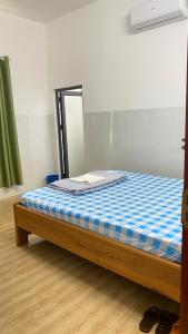 a bed in a room with a mirror at Nhà Nghỉ PHÚC THỊNH 