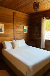 a bedroom with a large bed in a wooden room at Casa de Campo no Circuito das Águas in Socorro