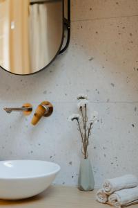 a bathroom with a sink and a vase with flowers at das haus - kisház a völgyben in Tarján