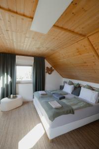 a bedroom with a large bed and a wooden ceiling at das haus - kisház a völgyben in Tarján