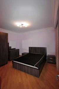 ein Schlafzimmer mit einem großen Bett und Holzböden in der Unterkunft Caliseum Sayat-Nova 33 in Yerevan