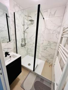 a white bathroom with a shower and a sink at LOCATION COURTE DUREE A BOISSY SAINT LEGER in Boissy-Saint-Léger