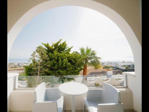 a room with a white table and chairs and a window at my life suites in Fira