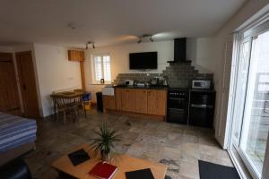 a living room with a kitchen with a stove top oven at Lynton Lodge Studios in Keswick +53 photos