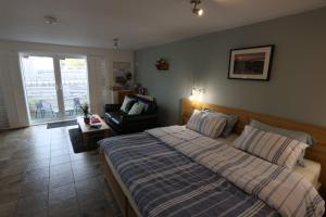 a bedroom with a bed and a chair in it at Lynton Lodge Studios in Keswick