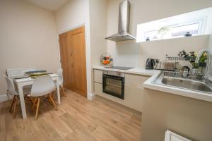 a kitchen with a sink and a table with chairs at Love Nest in Eastbourne in Eastbourne +12 photos