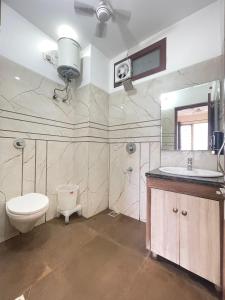 Un baño con inodoro, lavabo y espejo. en Hotel KD Inn Near Golden Temple, en Amritsar