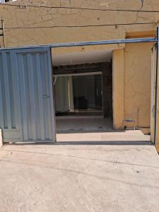 贝洛奥里藏特Casa espaçosa em Belo Horizonte的建筑物内有蓝色门的空车库