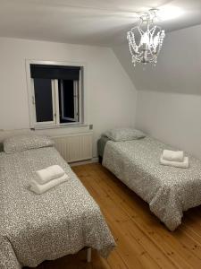 a bedroom with two beds and a chandelier at Pine Haven in Odense +27 photos