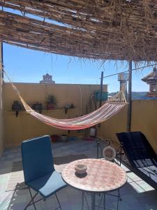 a hammock on a patio with a table and chairs at La Rosa dei Monti Iblei in Ferla