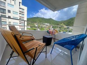 two chairs and a bench on a balcony with a view at El Rodadero, 4 habitaciones con piscina y terraza in Gaira