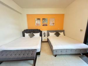 Una habitación con dos camas y un banco en ella. en 小路彎彎民宿 鄰近火車站 前庭有停車位, en Taitung