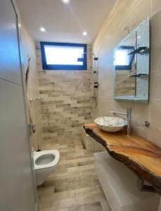 un baño con lavabo e inodoro en mykonos, en Tabarka