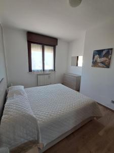 a white bedroom with a large bed in it at Interno 10 in Capolona