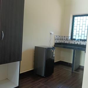 a room with a table and a small refrigerator at One love guest house in Morjim +25 photos