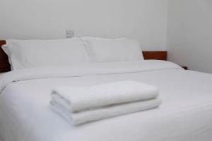 a white bed with white blankets and pillows at Modern Guest House 1BR in Nakuru