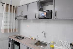 a small kitchen with a sink and a microwave at Modern Guest House 1BR in Nakuru