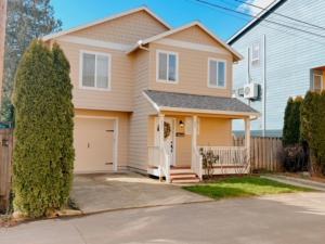 a brown house with a garage and a fence at Centrically Located Hillsboro Home in Hillsboro