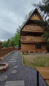 a log cabin with a pathway next to a building at Chata Sovička in Kokava na Rimavica