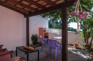 a patio with a purple chair and a table at Casas do Patio sem Cantigas 1 in Sintra