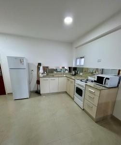 a kitchen with white appliances and a white refrigerator at Lofts & Suites in Rosario