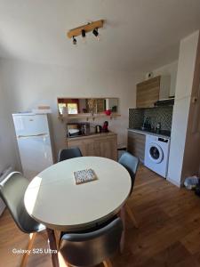 a kitchen with a table and chairs in a room at Appartement RDC - Grau du Roi in Le Grau-du-Roi +5 photos