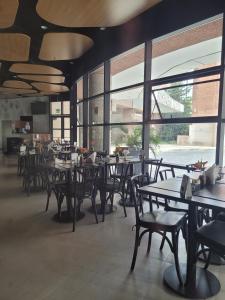 a restaurant with tables and chairs and large windows at Hotel Beneficência Bela Vista Com Garagem 1004 in Sao Paulo