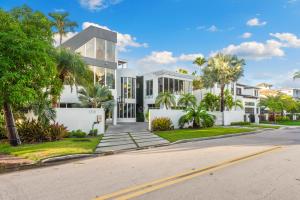 Una gran casa blanca con palmeras y una calle. en Villa Seminole, en Fort Lauderdale 173 fotos más