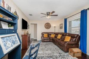 メルボルンにある3BR Oasis - Close to FIT, Downtown and Beachesのソファと天井ファンのあるリビングルーム