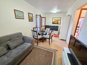 a living room with a couch and a table at Capivari Flat in Campos do Jordão
