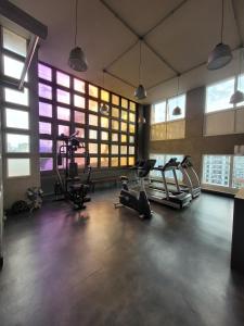 a gym with cardio equipment in a large room with windows at Hotel Beneficência Bela Vista Com Garagem 1004 in Sao Paulo