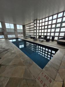 a large swimming pool in a building with windows at Hotel Beneficência Bela Vista Com Garagem 1004 in Sao Paulo