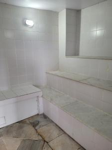 an empty bathroom with white tiles and a mirror at Hotel Beneficência Bela Vista Com Garagem 1004 in Sao Paulo +25 photos