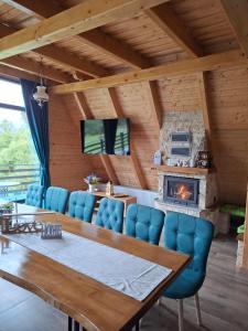 a dining room with a table and a fireplace at Cabana 3 Stejari Maramureș in Călineşti