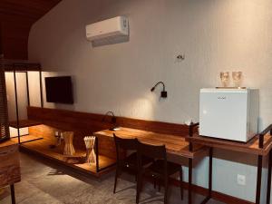 a room with a table with chairs and a television at Flor do Umarí Eco Hotel e Eventos in Serra de São Bento +16 photos